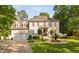 Stunning white brick home featuring a circular balcony, water fountain, lush landscaping and a three-car garage at 106 Clendenen Ct, Cary, NC 27513