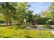 Lush front yard with a fountain feature, and a basketball hoop, complemented by mature trees and landscaping at 106 Clendenen Ct, Cary, NC 27513
