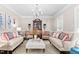 Bright living room features a chandelier, hardwood floors and elegant furniture at 106 Clendenen Ct, Cary, NC 27513