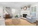 Sunlit living room boasting hardwood floors, a fireplace, comfortable seating and neutral-colored walls at 106 Clendenen Ct, Cary, NC 27513