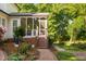 Cozy screened porch features brick steps, white railings and a meticulously landscaped yard at 106 Clendenen Ct, Cary, NC 27513
