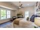 Bright bedroom featuring a ceiling fan, hardwood floors, large windows and a designer accent chair at 107 N Guthrie Ave, Durham, NC 27703