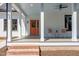 Inviting front porch with stylish seating, a painted ceiling and an orange front door at 107 N Guthrie Ave, Durham, NC 27703