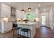 Bright kitchen featuring white cabinets, stainless steel appliances, and a center island with pendant lighting at 107 N Guthrie Ave, Durham, NC 27703