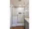 Bright, tiled shower with a glass door and unique black-and-white patterned tile floor at 107 N Guthrie Ave, Durham, NC 27703