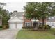 Charming two-story brick home featuring an attached two-car garage and a well-manicured lawn with mature trees at 110 Bristolwood Cir, Morrisville, NC 27560