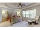 This main bedroom is spacious with a four-poster bed, ceiling fan, sitting area and lots of natural light at 110 Bristolwood Cir, Morrisville, NC 27560