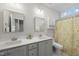 Bathroom features double vanity with vanity lighting, a marble countertop, and a shower with a gold patterned curtain at 110 Deacon Ridge Ln, Youngsville, NC 27596