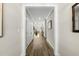 Inviting hallway with hardwood floors and neutral walls leading to a sun-filled living area at 110 Deacon Ridge Ln, Youngsville, NC 27596