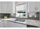 Bright kitchen features granite countertops, gray subway tile backsplash, and stainless steel sink and faucet at 110 Deacon Ridge Ln, Youngsville, NC 27596