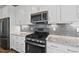 Modern kitchen showcases stainless steel appliances, white cabinets, and gray subway tile backsplash at 110 Deacon Ridge Ln, Youngsville, NC 27596