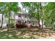 Back exterior of home with deck, surrounded by mature trees and landscaping at 110 Ferris Wheel Ct, Cary, NC 27513