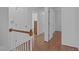 Upstairs hallway showing wood floors and trim with multiple access points to rooms at 110 Ferris Wheel Ct, Cary, NC 27513