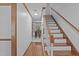 Hallway with hardwood flooring leading to a well-lit kitchen and staircase, offering a seamless transition at 110 Ferris Wheel Ct, Cary, NC 27513