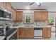 Kitchen with wood cabinets, tile backsplash, tile floor and a view to the wooded back yard at 110 Ferris Wheel Ct, Cary, NC 27513