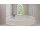 Bright bathroom with a soaking tub, a large window and clean neutral decor for relaxation at 112 Glenspring Way, Morrisville, NC 27560