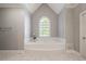 Bright bathroom with a soaking tub, a large window and clean neutral decor for relaxation at 112 Glenspring Way, Morrisville, NC 27560