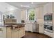 Modern kitchen featuring white cabinets, stainless steel appliances and a center island cooktop at 112 Glenspring Way, Morrisville, NC 27560