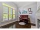 Sunlit room featuring a piano, large windows with shutters, and a cozy fireplace at 112 Glenspring Way, Morrisville, NC 27560