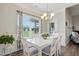 Bright dining room with modern chandelier, large windows, and white wood table at 116 Colonade Ct, Benson, NC 27504