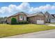 Classic brick home featuring lush lawn and a practical two-car garage at 116 Colonade Ct, Benson, NC 27504