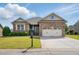 Inviting brick home with manicured lawn, complemented by a spacious driveway and two-car garage at 116 Colonade Ct, Benson, NC 27504