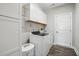 Laundry room with a washer, dryer, storage cabinets, wood floor and white door at 116 Colonade Ct, Benson, NC 27504