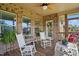 Porch with ceiling fan, wood floor, wooden railings and wicker furniture at 116 Colonade Ct, Benson, NC 27504