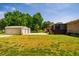 Lush backyard featuring multiple garages, mature trees, and a screened-in porch at 117 Castlerock Dr, Durham, NC 27713