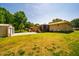 Expansive backyard with detached garages, a screened deck, and lush greenery at 117 Castlerock Dr, Durham, NC 27713