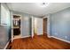 Bedroom featuring hardwood floors, light-blue walls, an attached bathroom, and a closet at 117 Castlerock Dr, Durham, NC 27713