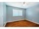 Bright bedroom with hardwood floors, ceiling fan, light-blue walls and a large window at 117 Castlerock Dr, Durham, NC 27713