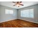 Bright bedroom with hardwood floors, two windows, and neutral paint, ready for personalization at 117 Castlerock Dr, Durham, NC 27713