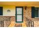 Close-up of the front door featuring a decorative tiled porch and a black wrought iron railing at 117 Castlerock Dr, Durham, NC 27713