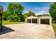 Spacious concrete driveway leading to a three-car metal garage, set against a backdrop of lush trees at 117 Castlerock Dr, Durham, NC 27713