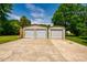 Three-car metal garage with individual roll-up doors, perfect for storing vehicles or equipment, and a concrete driveway at 117 Castlerock Dr, Durham, NC 27713