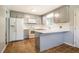 Renovated kitchen with modern white appliances, gray cabinets, and an eat-in breakfast bar at 117 Castlerock Dr, Durham, NC 27713