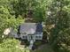 Aerial shot of white home with mature trees, lush landscaping, and rocking chairs on the front porch at 117 Queensferry Rd, Cary, NC 27511