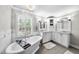Luxury bathroom featuring a soaking tub, dual vanities, plantation shutters, and elegant lighting at 117 Queensferry Rd, Cary, NC 27511