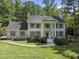 Stately white brick home with gray shutters, complemented by lush landscaping and a charming walkway at 117 Queensferry Rd, Cary, NC 27511