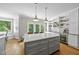 Bright kitchen with large island, quartz countertops, custom cabinets, and built-in bar area at 117 Queensferry Rd, Cary, NC 27511