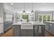 Spacious kitchen island with white countertop, farmhouse sink, and stainless steel appliances, great for cooking at 117 Queensferry Rd, Cary, NC 27511