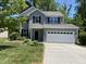 Charming two-story home with a well-manicured lawn and a two-car garage, nestled amidst lush greenery at 1208 Olympic Dr, Mebane, NC 27302
