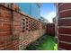 Brick wall with decorative cutouts bordering grassy area and a wooden gate at 1209 Harp St, Raleigh, NC 27604