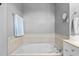 This bathroom features a neutral-toned tiled tub with chrome fixtures at 1209 Harp St, Raleigh, NC 27604