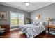Bedroom with hardwood floors, a ceiling fan, a comfortable bed and decorative furnishings at 1209 Harp St, Raleigh, NC 27604
