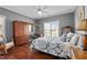 Cozy bedroom with hardwood floors, a ceiling fan, and a large patterned bed at 1209 Harp St, Raleigh, NC 27604