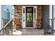 Inviting front porch with rocking chairs, stone accents, and black trimmed entry door at 1209 Harp St, Raleigh, NC 27604