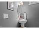 Chic powder room with pedestal sink, oval mirror, stylish lighting, and neutral wall color at 1209 Harp St, Raleigh, NC 27604