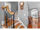 Staircase with hardwood steps, black wrought iron railing, and decorative tile risers at 1209 Harp St, Raleigh, NC 27604